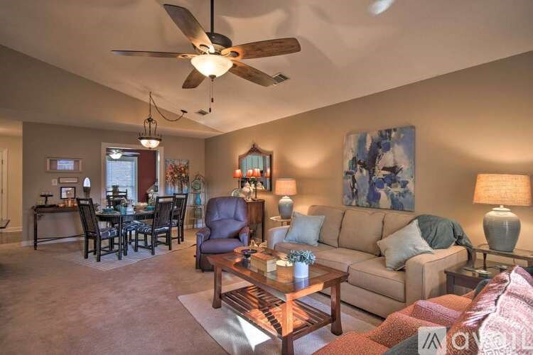 A living room with a brown sofa, a wooden coffee table, and a ceiling fan.