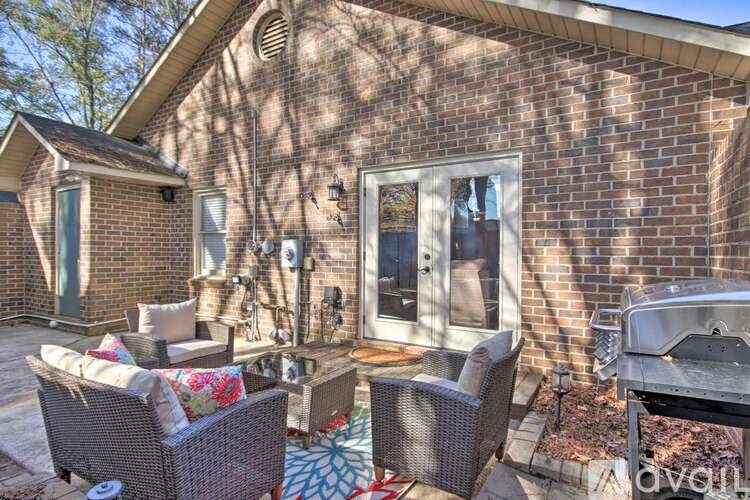 A patio with a table and chairs is set up outside a house.