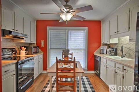 A kitchen with a table and chairs in the middle.