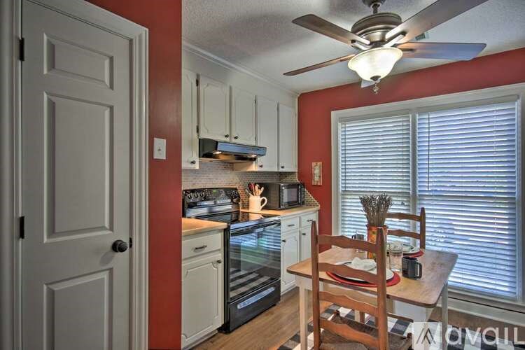 A kitchen with red walls and a ceiling fan.