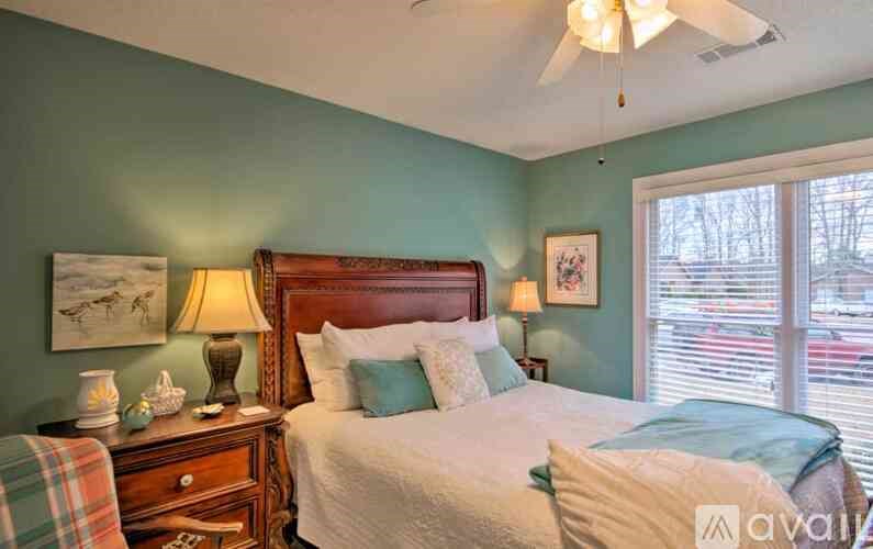 A bedroom with a bed, nightstand, and window.