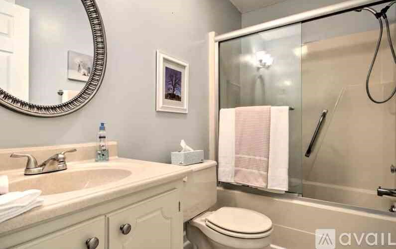 A bathroom with a sink, toilet, and shower.