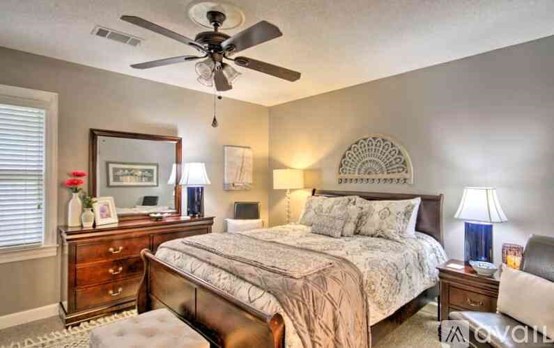 A bedroom with a bed, nightstand, and a ceiling fan.