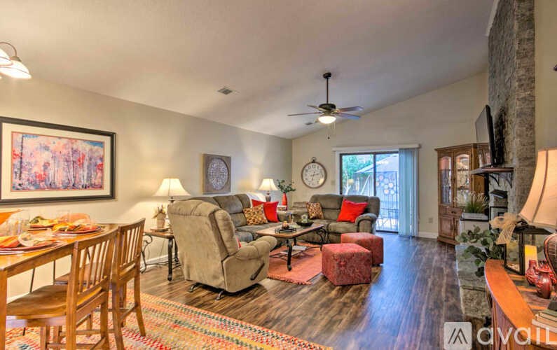 A living room with a couch, chairs, and a painting on the wall.