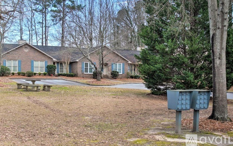 A house with blue shutters and a mailbox in front of it.