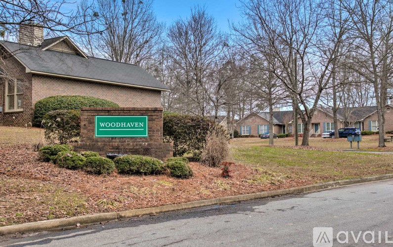 A sign that says Woodhaven in front of a house.