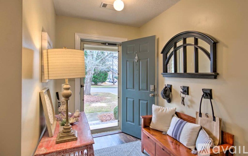 A living room with a couch, a lamp, a mirror and a door.