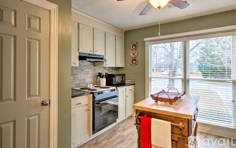 A kitchen with a stove, oven, and a fan.