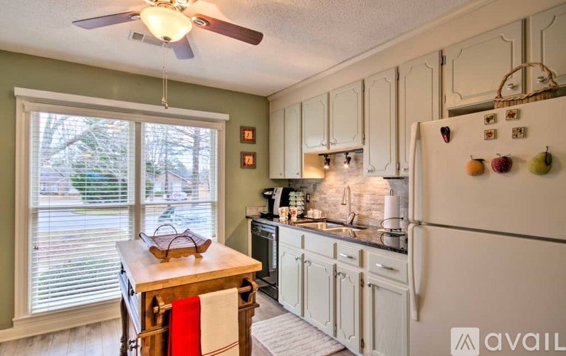 A kitchen with a refrigerator, table, and chairs.