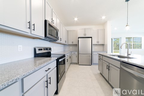 A kitchen with white cabinets and a granite countertop.