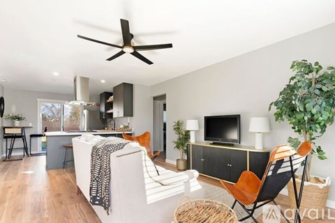 A living room with a white couch and a ceiling fan.