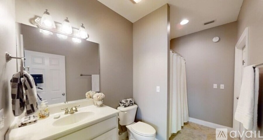 A bathroom with a toilet, sink, and mirror.