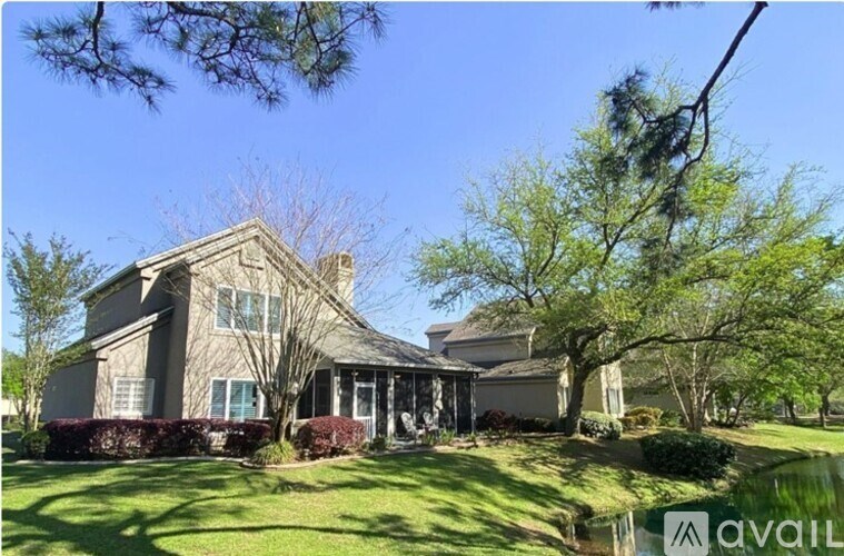 A house with a well-maintained lawn and trees in the background.