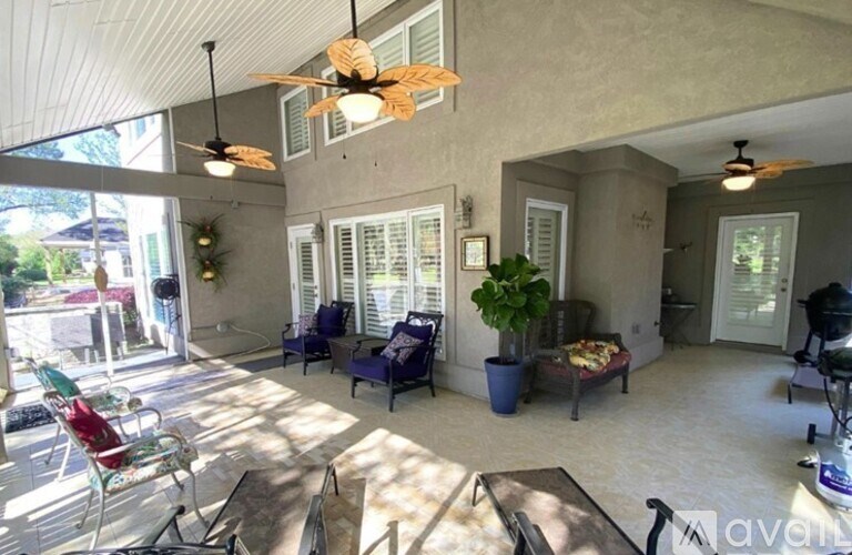 A sunny day in a spacious patio with a table and chairs.