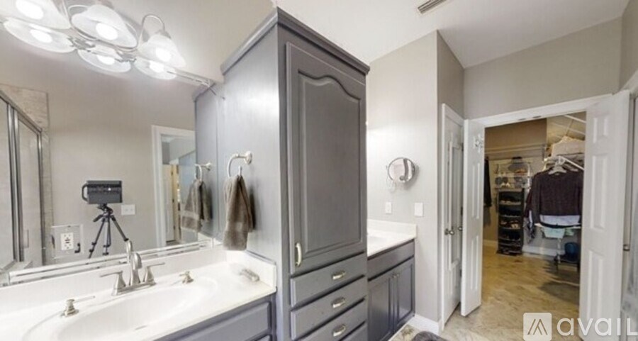 A bathroom with a sink, mirror, and cabinets.