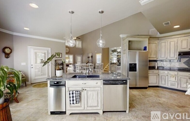 A modern kitchen with a center island and stainless steel appliances.