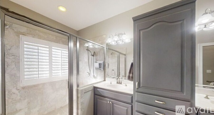 A bathroom with a walk-in shower, double sinks, and a large mirror.