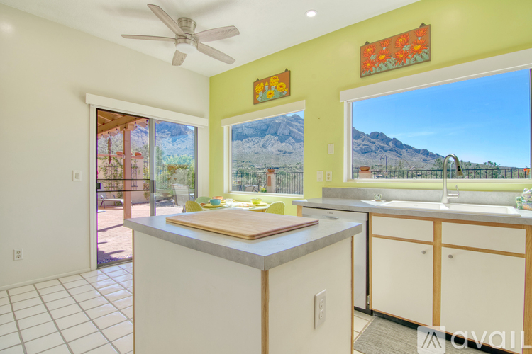 A kitchen with a white counter top and a ceiling fan.