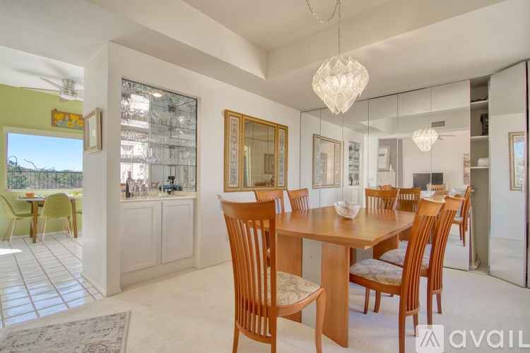 A dining room with a wooden table and chairs.