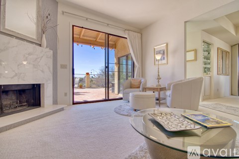 A modern living room with a glass table and a fireplace.