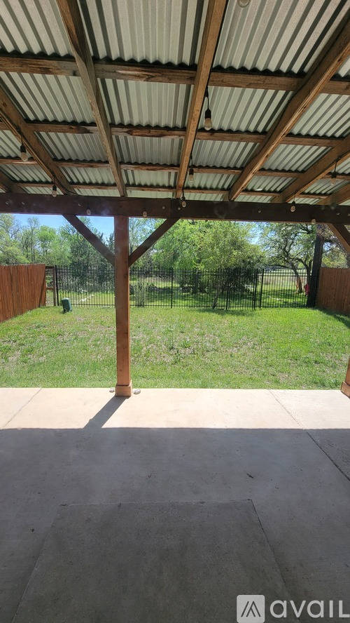 A patio with a roof and a concrete floor.