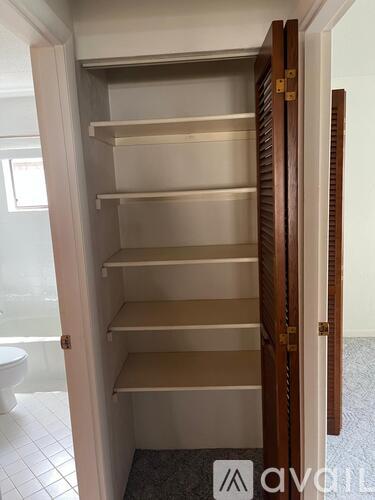 Empty shelves in a white pantry.