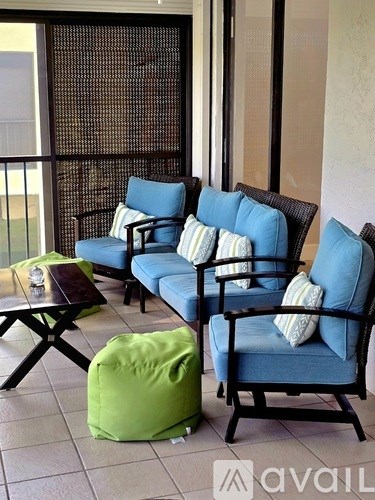 A patio with blue chairs and a green bean bag.