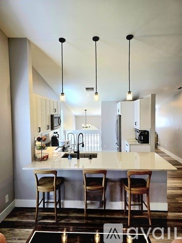 A modern kitchen with a bar stool and a counter.