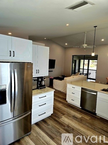 A kitchen with white cabinets and a stainless steel refrigerator.