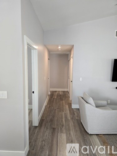 A living room with a couch and a television on the wall.