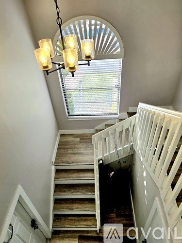 A staircase with a chandelier hanging above it.