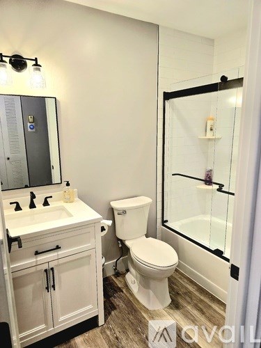 A white toilet sits in a bathroom next to a sink and mirror.