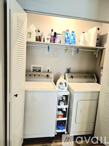A small, white laundry room with a washer and dryer.