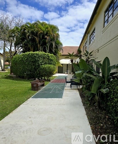 A green hedge is in front of a white building.