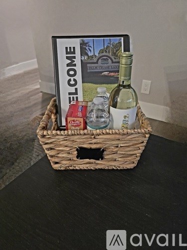 A welcome basket with a bottle of wine, a box of crackers, and a bottle of water.