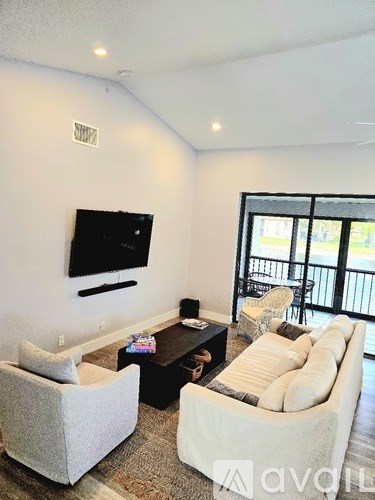 A living room with a flat screen TV mounted on the wall.