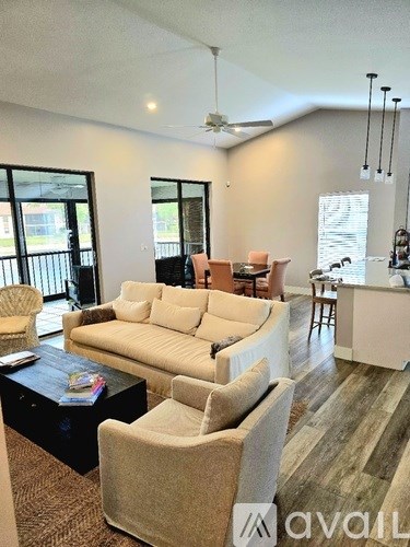A living room with a white couch, a black coffee table, and a rug.