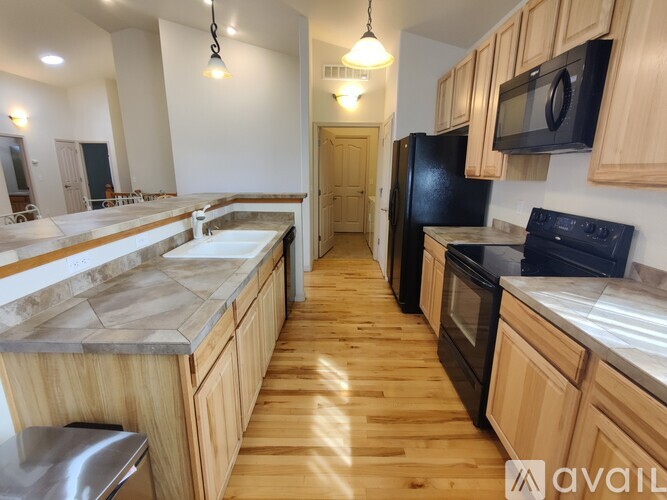 A kitchen with wooden cabinets and black appliances.