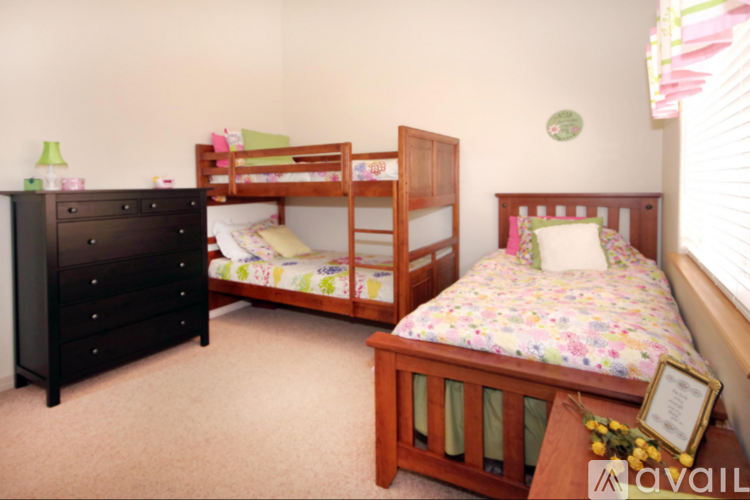A bedroom with a black dresser and two beds.