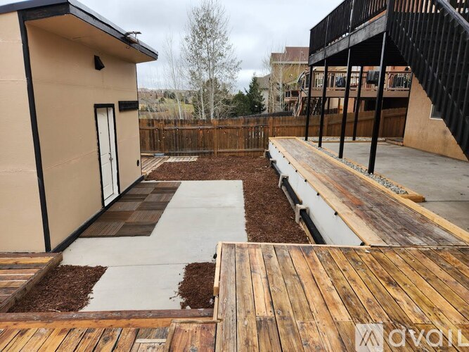 A patio area with a wooden deck and a concrete walkway.