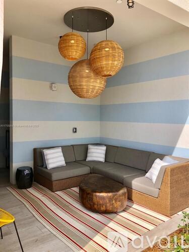 A living room with a grey couch, a yellow chair and a striped rug.