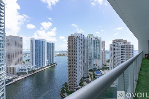 A view from a balcony overlooking a river and buildings.