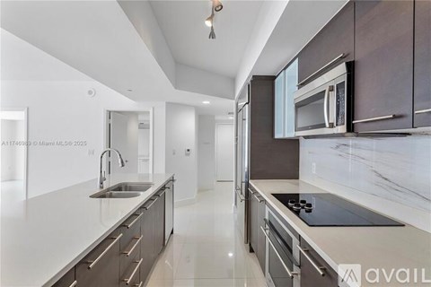A modern kitchen with dark brown cabinets and white countertops.