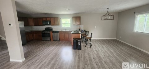 A kitchen with wooden cabinets and a dining table with chairs.