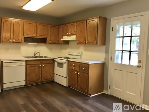 A kitchen with wooden cabinets and white appliances.