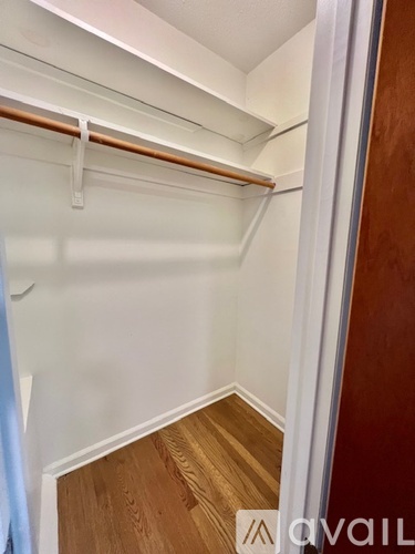 A spacious room with a staircase and a window overlooking a street.
