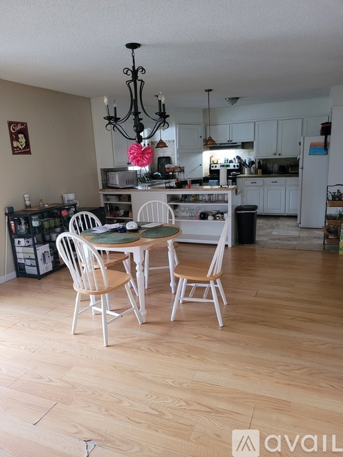 A kitchen with a dining table and chairs.