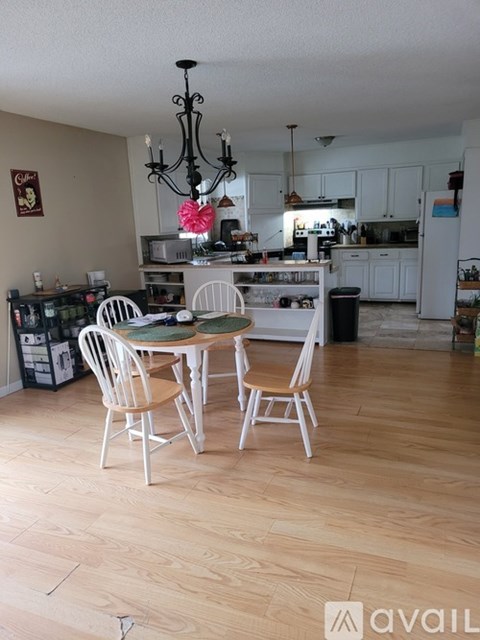 A kitchen with a dining table and chairs.