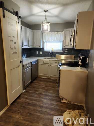 A kitchen with a white fridge and a wooden floor.