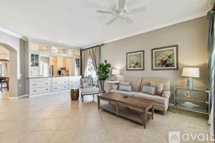 A spacious living room with a ceiling fan and a coffee table.